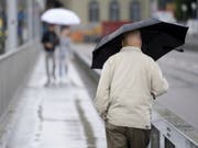 Viel Regen über der Schweiz: Personen mit Regenschirmen gehen auf der Kirchenfeldbrücke in Bern. (Bild: Keystone/ANTHONY ANEX)