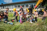 Die Kindergärtler feiern den Spatenstich auf der Wiese hinter dem Primarschulhaus Wehrli. (Bild: Reto Martin)