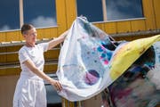 Lika Nüssli schwenkt eines ihrer farbigen Leintücher vor dem Lattich-Bau im alten St.Galler Güterbahnhof. (Bilder: Adriana Ortiz Cardozo - 13. Juni 2019)