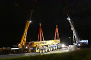 Der Pneukran wurde in einer logistisch aufwendigen Bergungsaktion von zwei weiteren Kranen angehoben und auf einen Tieflader gestellt. (Bild: Kapo SG)