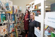 Andrea Schlegel und Nadja Eberle (von links) zwischen den dichtegrängten Ständern und Regalen mit Medien für den Flohmarkt. (Bild: Johannes Wey)