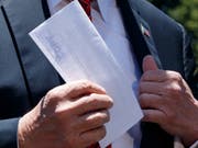US-Präsident Donald Trump zeigte am Dienstag den zusammengefalteten Brief Journalisten vor seiner Abreise an einen Wahlkampfauftritt im US-Staat Iowa. (Bild: KEYSTONE/AP/EVAN VUCCI)