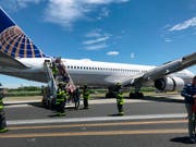 Rettungspersonal hilft bei der Evakuierung eines Flugzeugs der United Airlines, das auf dem Flughafen Newark bei New York teilweise von der Landebahn abgekommen ist. (Caroline Craddock via AP) (Bild: KEYSTONE/AP Caroline Craddock)
