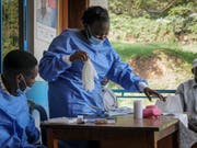 Das Gesundheitspersonal zieht in einem Spital im Westen Ugandas Schutzkleidung an, bevor es mit dem Impfen von Menschen gegen Ebola beginnt. (AP Photo/Ronald Kabuubi) (Bild: KEYSTONE/AP/RONALD KABUUBI)