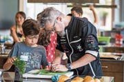 Tipps vom Starkoch: Im Oberstufenzentrum Buechenwald zeigt Rolf Caviezel den Kindern, worauf es beim Kochen ankommt. (Bild: Michel Canonica)