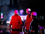 Mitarbeiter einer Energiefirma bei der Arbeit im Regen in der argentinischen Hauptstadt Buenos Aires. (Bild: KEYSTONE/AP/TOMAS F. CUESTA)