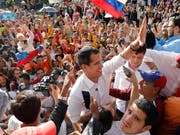 Venezuelas Oppositionsführer Juan Guaidó (Mitte) hat am Samstag seinen Anhängern erneut Mut gemacht, dass die Regentschaft von Staatschef Nicolás Maduro bald zu Ende sein werde. (Bild: KEYSTONE/AP/ARIANA CUBILLOS)