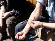 Drogensüchtiger setzet sich einen Heroin-"Schuss». (Bild: KEYSTONE/STR)
