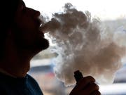 Ist bei vielen Jugendlichen beliebt, gilt aber als umstritten: Das Qualmen von E-Zigaretten. (Bild: KEYSTONE/AP/STEVE HELBER)