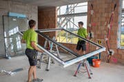 Mitarbeitende der Edelweiss Fenster AG bauen ein Fenster ein. (Bild: PD)