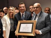Der neue Bürgermeister von Istanbul, Ekrem Imamoglu (Mitte), präsentiert seine Ernennungsurkunde. (Bild: KEYSTONE/AP Pool Imamoglu Press Team)