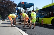 Die Strassenbauer trotzen der Hitze beim Belagseinbau in Trübbach. (Bilder: Corinne Hanselmann)