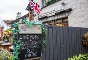 Ein klassisches Pub im nordenglischen Bowness-on-Windermere wirbt für sein altbewährtes Programm.Bild: Martin Berry/Alamy