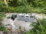 Der Angestellte fand Traktor und Anhänger im Bach wieder. (Bild: Kapo GR)