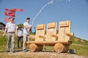 Jürg Balsiger, Direktor der Stanserhorn-Bahn (links), und Patrick Heymann, Chief Commercial Officer der Fluglinie Edelweiss, weihen das Bänkli schwungvoll ein. (Bild: PD)