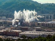 Nach der Sprengung der letzten beiden Pfeiler der Unglücksbrücke hängt eine Staubwolke über Genua. (Bild: KEYSTONE/AP/ANTONIO CALANNI)