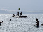 Abkühlung von der Hitze im Neuenburgersee - am Sonntag war es in Sitten 37 Grad heiss. (Bild: Keystone/ANTHONY ANEX)