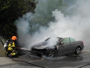 Das Feuer wird gelöscht, am Wagen entsteht aber Totalschaden. (Bild: Kantonspolizei Schwyz)