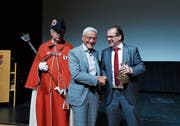 Gemeindepräsident Georges Helfenstein (rechts) überreicht Josef Huwiler den bronzenen Bären der Sparte Wirtschaft. Links im Bild Gemeindeweibel Peter Stalder. (Bild: Stefan Kaiser (Cham, 5. Juni 2019))