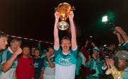 Jürgen Mohr stemmt am 10. Juni 1989 nach dem 1:0-Heimsieg gegen Servette auf der Luzerner Allmend den Meisterpokal in die Höhe. (Bild: Keystone)