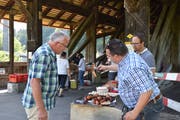Gemeinderat Ruedi Epper (Bratwurst hochhaltend) und Ratsschreiber Andreas Breitenmoser waren leidenschaftliche Grillmeister. (Bild: Timon Kobelt)