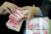 Ein Bündel chinesischer Banknoten in einer Bank in Wuhan. Chinesische Unternehmen sind nach wie vor auf Einkaufstour in Europa und der Schweiz. (Bild: AP)