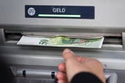 A person takes a fifty Swiss franc bill out of a cash dispenser while withdrawing money, photographed in Zurich, Switzerland, on September 22, 2015. (KEYSTONE/Christian Beutler)Eine Person entnimmt waehrend des Geldbezuges eine fuenfzig Franken Banknote aus einem Bankautomaten, aufgenommen am 22. September in Zuerich. (KEYSTONE/Christian Beutler)