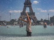 Während der Hitzewelle im Juni suchen Einwohner von Paris Abkühlung in öffentlichen Brunnen. Weltweit müssen sich Metropolen auf eine Erwärmung des Stadtklimas einstellen. (Bild: Ian Langsdson/EPA Keystone) (Bild: KEYSTONE/EPA/IAN LANGSDON)