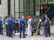 Polizisten räumten am Montag die Blockade der Aktivisten einer Gruppe namens «Collective Climate Justice» vor dem UBS-Bürogebäude am Aeschenplatz in Basel. Im Hintergrund eine Holzbeige, die an Schwemmholz erinnert, als Sperre vor der Türe. (Bild: KEYSTONE/GEORGIOS KEFALAS)