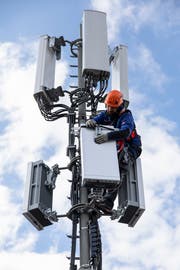 Ein Swisscom-Mitarbeiter installiert ein Element einer 5G-Antenne. (Bild: KEYSTONE/Peter Klaunzer)