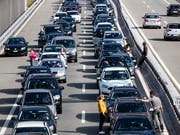 Warten auf die Ferien: Autofahrerinnen und Autofahrer im Stau vor dem Gotthard-Nordportal. (Bild: KEYSTONE/ALEXANDRA WEY)