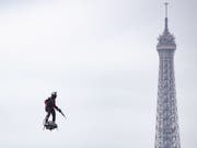 Der französische Jetski-Rennfahrer Franky Zapata flog mit seinem Flyboard Air über die Champs Elysées. (Bild: Keystone/EPA/IAN LANGSDON)