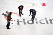 Sieht ein bisschen aus wie Curling: die Werbebanner werden mit Gummirechen glattgestrichen. (Bild: Stefan Kaiser, Zug, 17. Juli 2019)