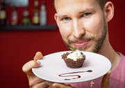 Daniel Birchler mit einem knusprigen Cupcake aus Grillenmehl. Bild: Urs Bucher
