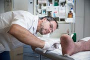Theo Köhler versorgt im Wundambulatorium Luzern die Wunde eines Patienten. (Bild: Manuela Jans-Koch, 18. Juli 2019)