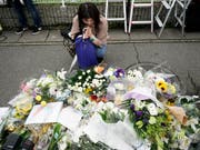 Nach dem Brandanschlag auf ein Trickfilm-Studio in Kyoto legen Anwohner Blumen nieder und beten für die Opfer. (Bild: KEYSTONE/AP/JAE C. HONG)