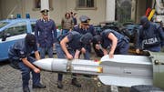 Italienische Polizisten mit der sichergestellten Luft-Luft-Rakete. (Bild: Polizei Turin)