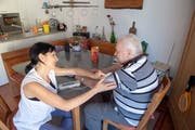 Pflegerin Ramona Walser misst dem pensionierten Bauer Werner Spörri * nach der Körperpflege den Blutdruck. (Bild: Urs Bucher, Mels, 16. Juli 2019)