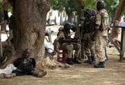 Zehn Jahre ist es her, seit die islamistische Terrortruppe Boko Haram Schülerinnen entführte. Hier nigerianische Soldaten und ein Verdächtiger. (Bild: Sunday Alamba/AP)
