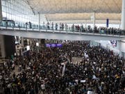 Hunderte Demonstranten haben sich zu Protesten im Flughafen von Hongkong versammelt. Sie wollen insbesondere Besucher vom chinesischen Festland über die Anti-Regierungsproteste informieren. (Bild: KEYSTONE/EPA/JEROME FAVRE)