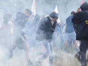 Bei einer Protestkundgebung gegen den Bau einer umstrittenen Bahnstrecke zwischen Turin und Lyon bewarfen vermummte Demonstranten die Polizisten mit Steinen. Diese reagierte mit Tränengas. (Bild: KEYSTONE/EPA ANSA/ALESSANDRO DI MARCO)