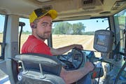 Stefan Pichel fährt mit seinem Traktor über ein abgeerntetes Getreidefeld und presst dabei Strohballen. (Bild: Mario Testa)