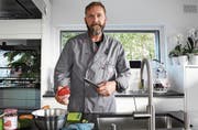 Michael Vogt, Präsident des Kochklubs Thurchuchi, steht in seiner Küche in Sulgen und schneidet Gemüse.Bild: Yvonne Aldrovandi-Schläpfer