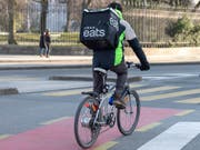 Die Essenslieferdienste Takeaway.com und Just Eat fusionieren - und dürften damit gegenüber neu eintretenden Playern auf dem Markt wie Uber Eats in einer noch besseren Position sein. Im Bild: Uber-Eats-Velokurier in Genf (Archivbild). (Bild: KEYSTONE/MARTIAL TREZZINI)
