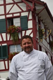 Reto Kropf vor dem Riegelhaus mit Blumenschmuck, wo er seit 20 Jahren am Herd steht. (Bild: Markus Schoch)