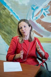 Bernadette Zürcher in ihrem Büro vor dem Bild «Die gute Wand» des Malers André Wilhelm, das sich im Besitz des Kantons Zug befindet und sie sich ausgesucht hat. Ihr werde nie langweilig, wenn sie es betrachte. (Bild: Maria Schmid, Zug, 27. Juni 2019)