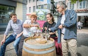 Daniel Bauer, Charles Salathé, Caroline Schwar und Armin Strom geben beim Meitlibrunnen einen praktischen Vorgeschmack auf das Winzerfest. (Bild: Andrea Stalder)
