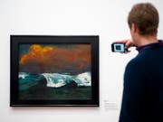 Ein Ausstellungsbesucher macht ein Foto von Emil Noldes Gemälde «Brecher» von 1936. Emil Nolde (1867-1956) ist eine Ikone des Expressionismus. Er war aber auch Unterstützer des Nationalsozialismus. eine Ausstellung in Berlin setzt sich kritisch mit seinem Werk auseinander. (Bild: KEYSTONE/AP/MARKUS SCHREIBER)