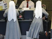 Ordensfrauen am Check-in im Flughafen. Sommerzeit ist Ferienzeit - allerdings nicht für jeden und jede. In der EU können sich im Schnitt 28,3 Prozent der Bürger nicht einmal eine Woche Urlaub leisten. In der Schweiz müssen nur 8,5 Prozent aus Kostengründen daheim bleiben. (Bild: Keystone/STEFFEN SCHMIDT)