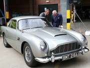 Schauspieler Daniel Craig und Prinz Charles freuen sich am Aston Martin «Bond-Auto» - weniger Freude haben derzeit allerdings die Aktionäre des Autoherstellers an ihren Papieren. (Bild: KEYSTONE/AP PA/CHRIS JACKSON)